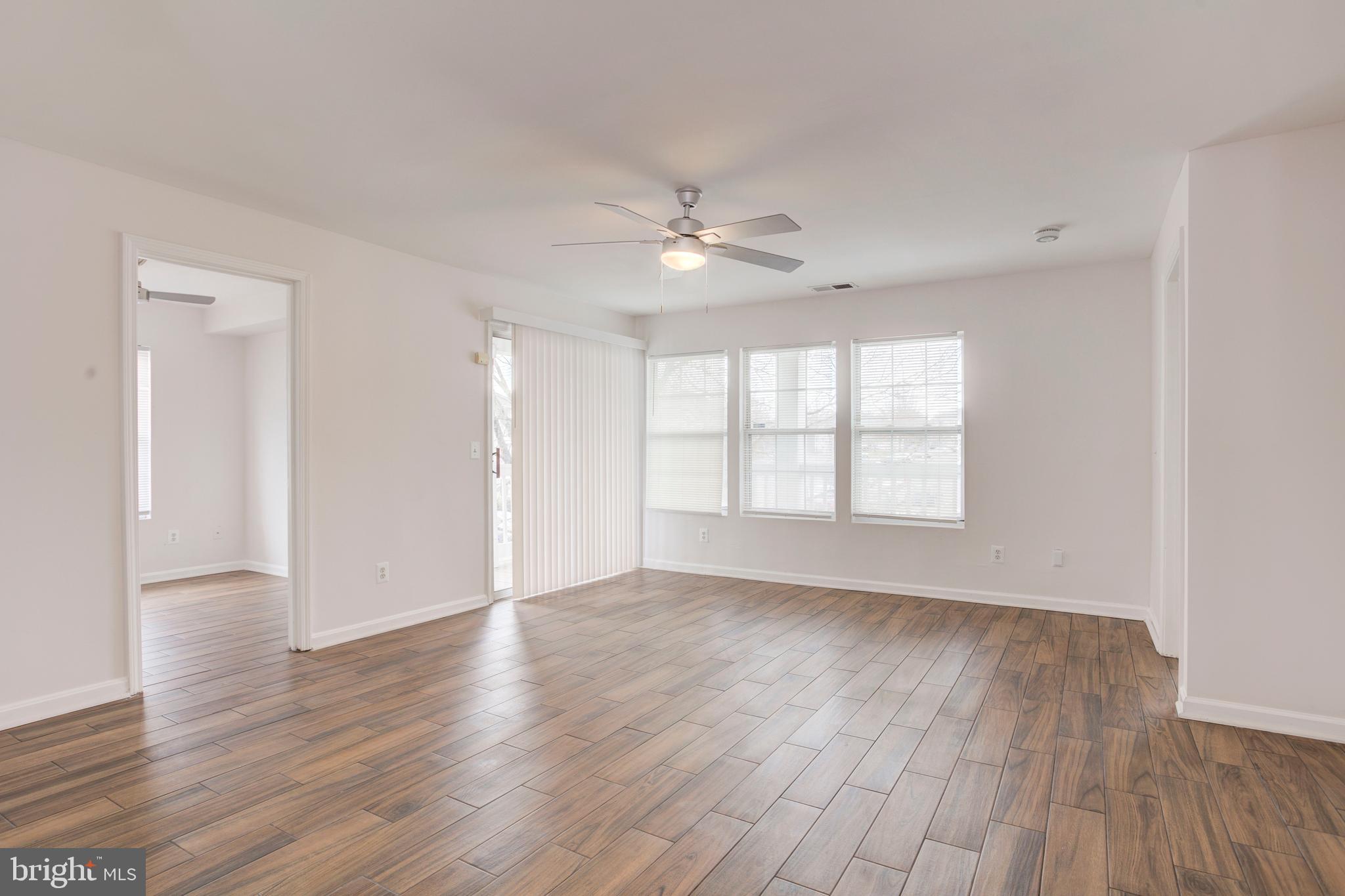 14174 Cuddy Loop, Unit 204 Woodbridge, VA 22193 - Photo 3 of 24 an empty room with wooden floor and windows