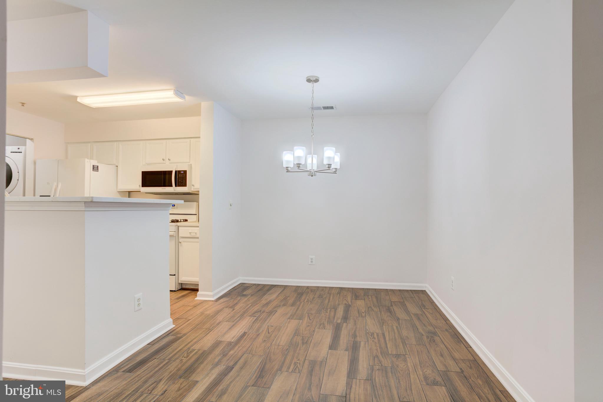 14174 Cuddy Loop, Unit 204 Woodbridge, VA 22193 - Photo 8 of 24 a view of a kitchen with wooden floor and a window