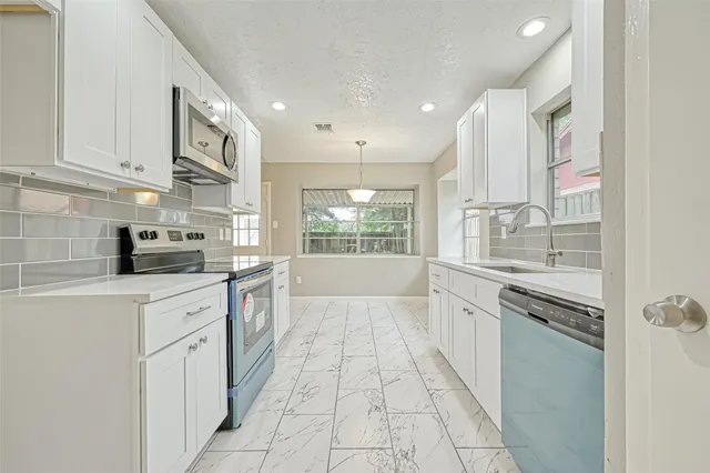 a kitchen with stainless steel appliances granite countertop a sink and a stove