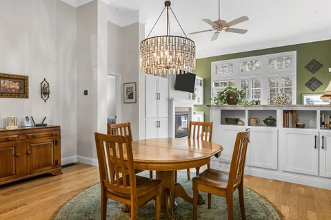 a dining room filled chandelier and kitchen view