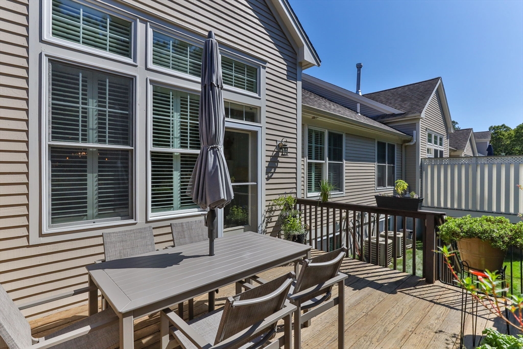 116 Grey Hawk Drive, Unit 116 Mashpee, MA 02649 - Photo 30 of 41 a view of a deck with a table and chairs