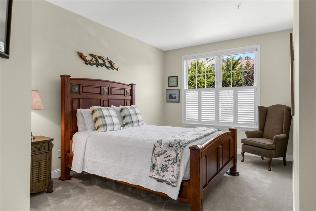 116 Grey Hawk Drive, Unit 116 Mashpee, MA 02649 - Photo 5 of 41 a bedroom with a bed chair and a window