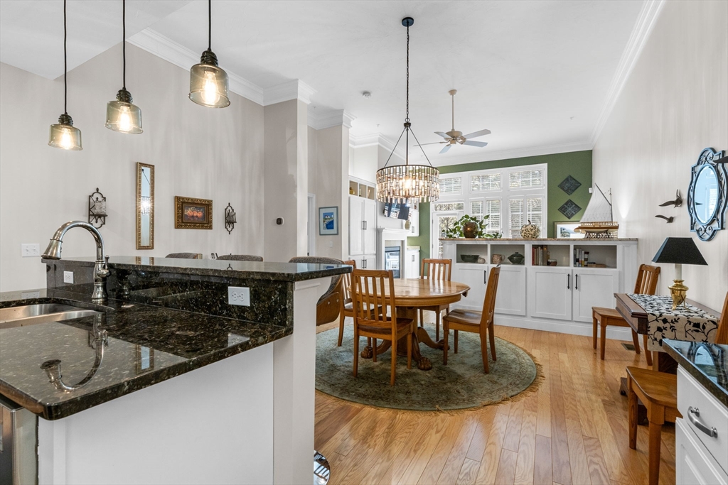 116 Grey Hawk Drive, Unit 116 Mashpee, MA 02649 - Photo 8 of 41 a kitchen with a table chairs and a chandelier
