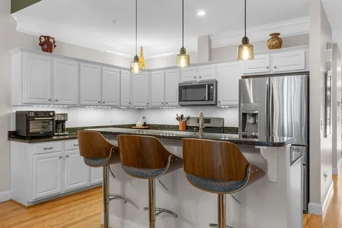 a view of a dining room with furniture a chandelier and wooden floor