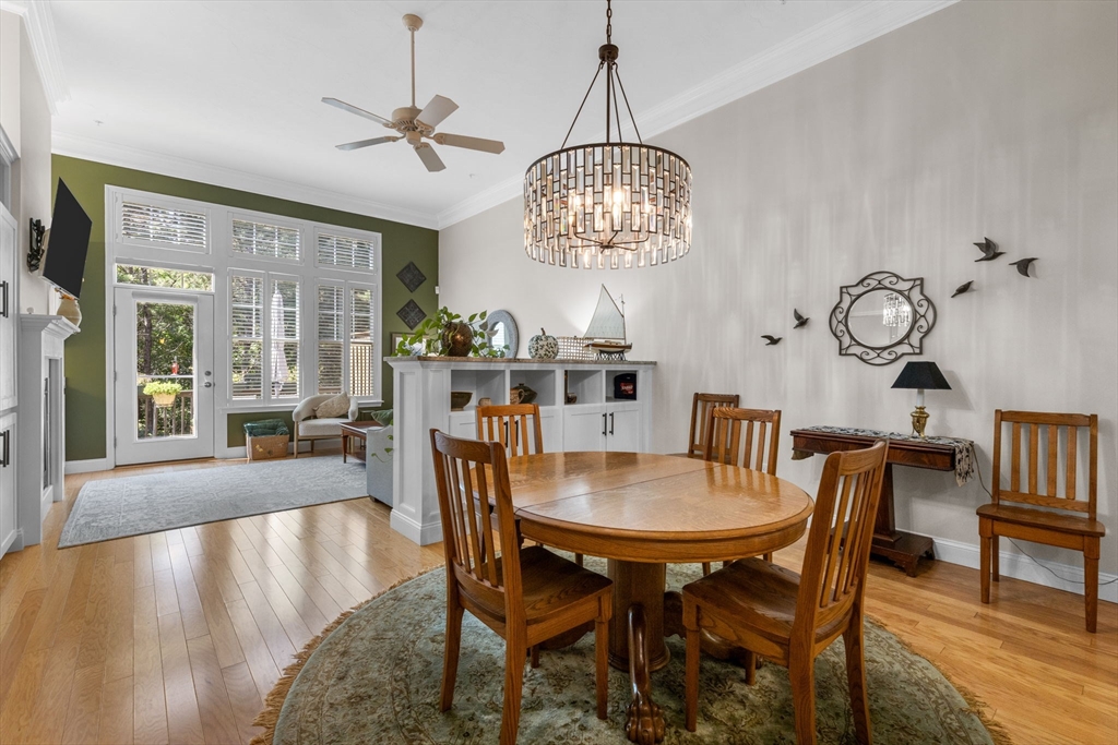 116 Grey Hawk Drive, Unit 116 Mashpee, MA 02649 - Photo 10 of 41 a view of a dining room with furniture a chandelier and wooden floor