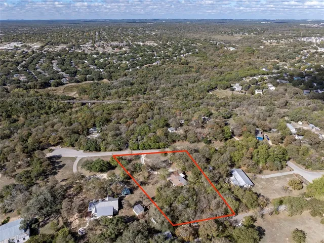 an aerial view of house with yard and mountain view in back