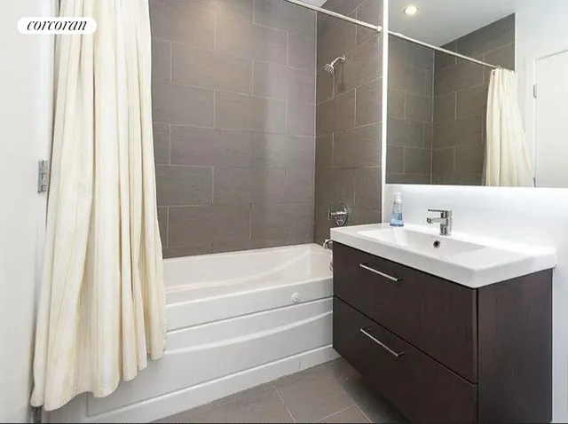 a bedroom with a bed and a flat tv screen on a dresser