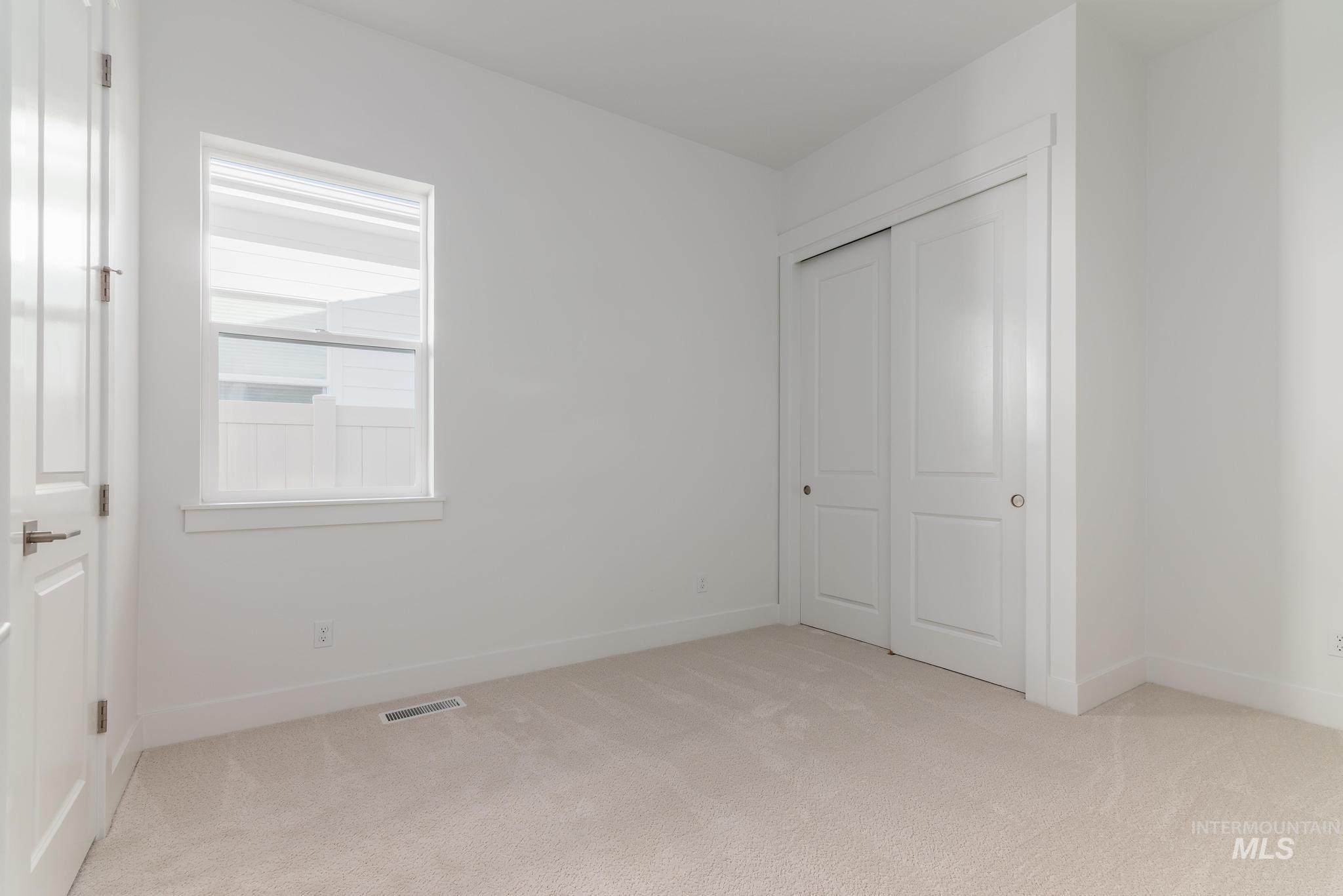 9074 West Moonglade Street Star, ID 83669 - Photo 22 of 40 Room featuring light beige carpeting, white walls, and a white-framed window