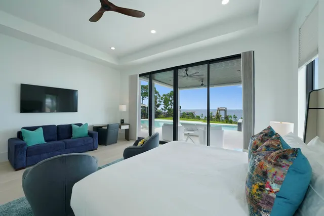 a bedroom with a large bed and a painting on the wall