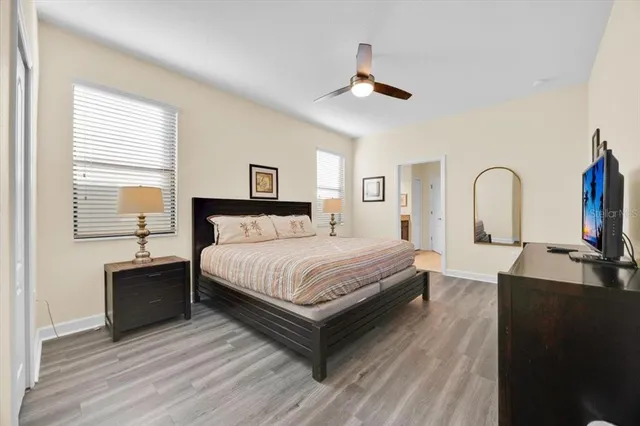 a bedroom with a bed wooden floor and window