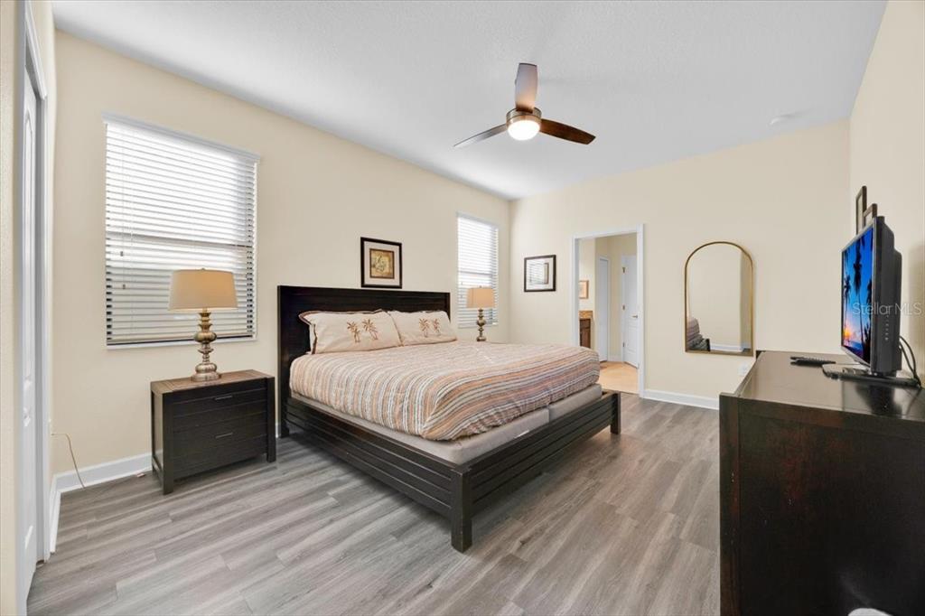 9032 Shadow Mountain Street Davenport, FL 33896 - Photo 11 of 43 a bedroom with a bed wooden floor and window