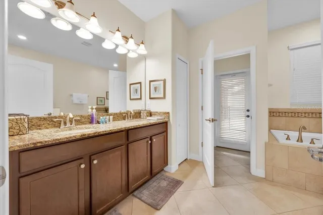 a spacious bathroom with a granite countertop sink a large mirror and a shower