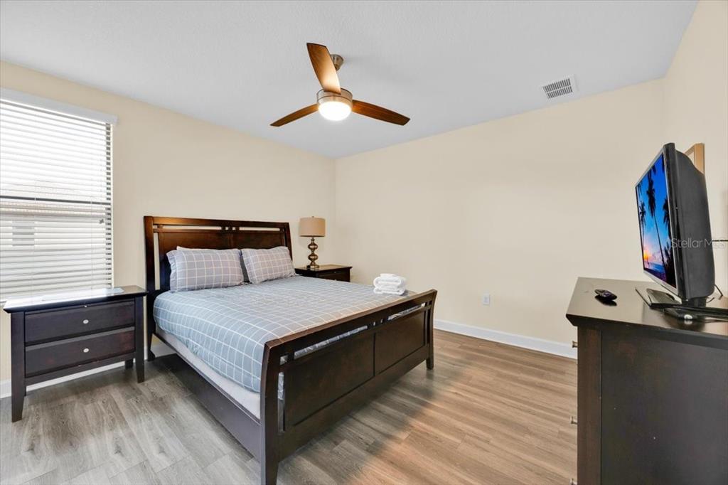 9032 Shadow Mountain Street Davenport, FL 33896 - Photo 19 of 43 a bedroom with a bed and a flat screen tv