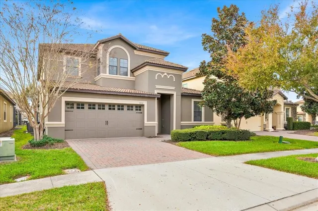 a view of a house with a yard and large tree