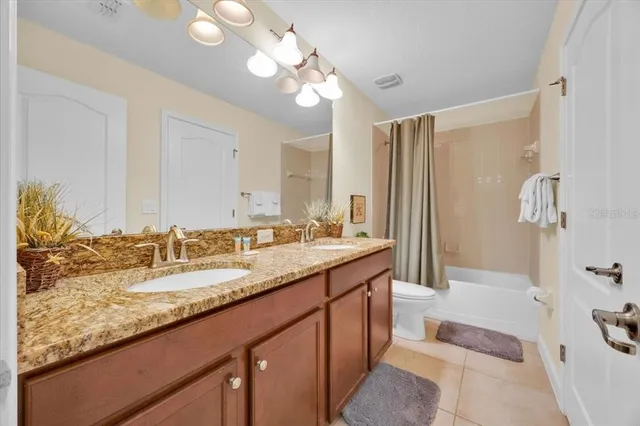 a bathroom with a granite countertop sink mirror and a bath tub