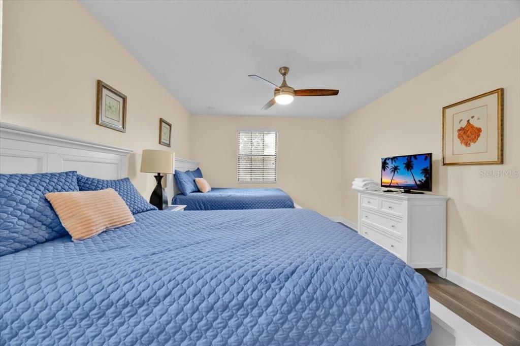 9032 Shadow Mountain Street Davenport, FL 33896 - Photo 24 of 43 a bedroom with a large bed and a flat screen tv