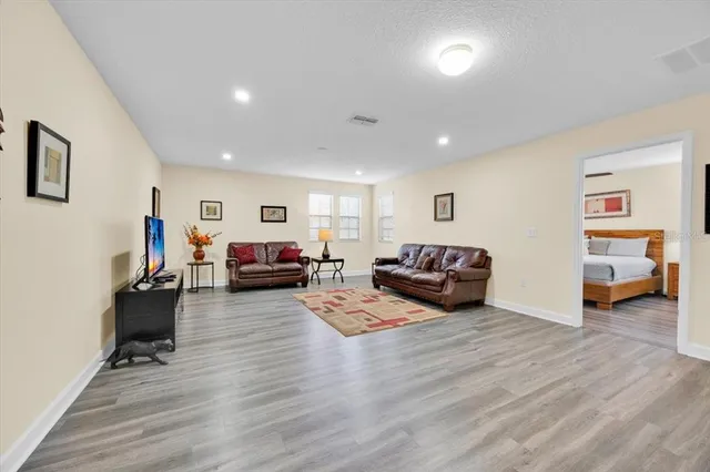 a living room with furniture and a wooden floor