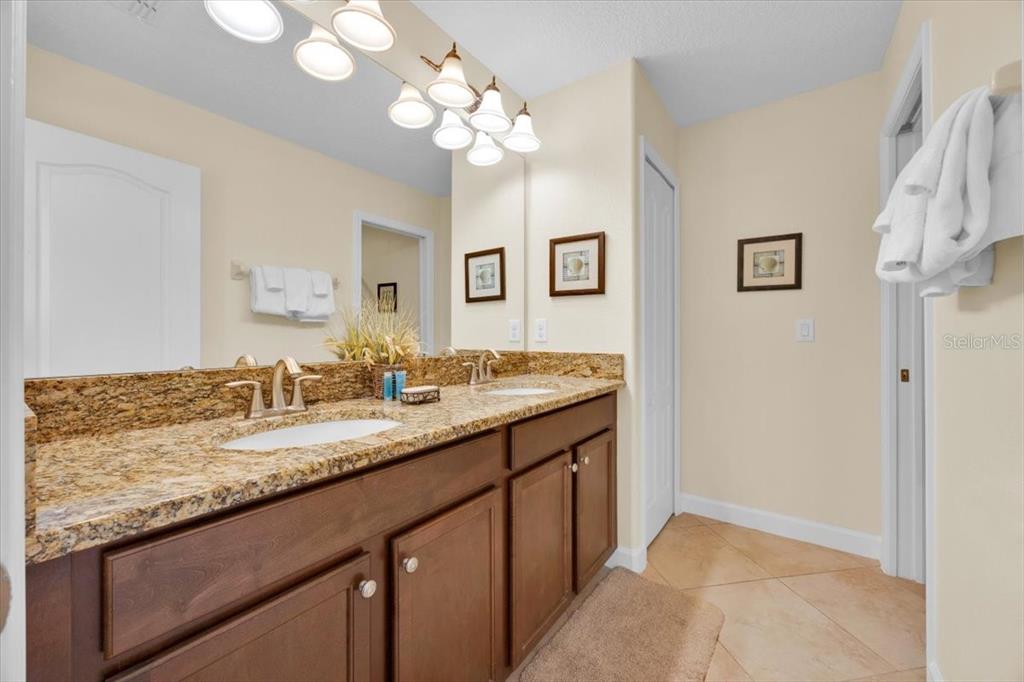 9032 Shadow Mountain Street Davenport, FL 33896 - Photo 29 of 43 a bathroom with a granite countertop double vanity and a mirror