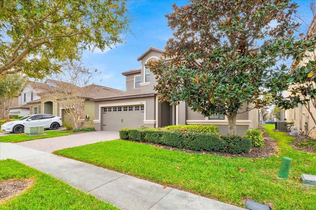 9032 Shadow Mountain Street Davenport, FL 33896 - Photo 3 of 43 a view of house in front of a big yard with large trees plants and large trees