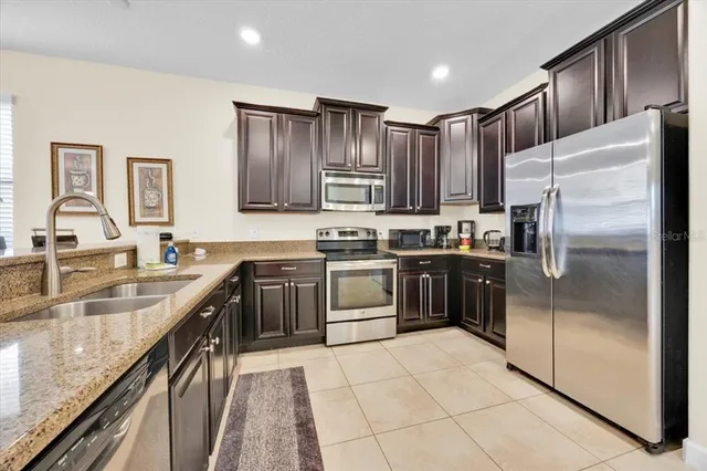 a kitchen with stainless steel appliances granite countertop a refrigerator stove and sink