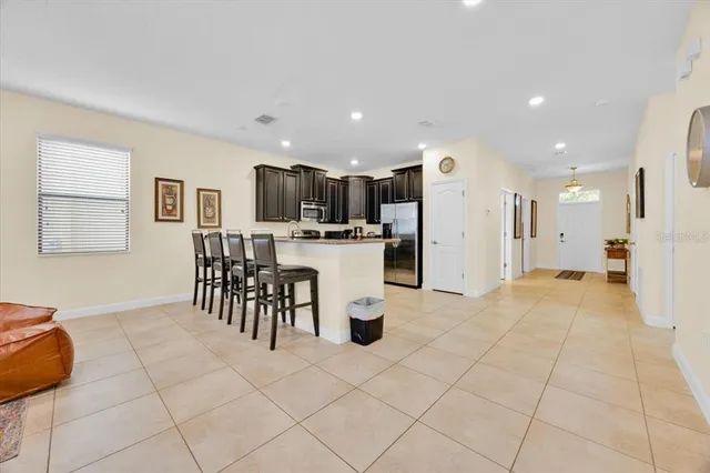 a kitchen with stainless steel appliances kitchen island granite countertop a refrigerator and a sink