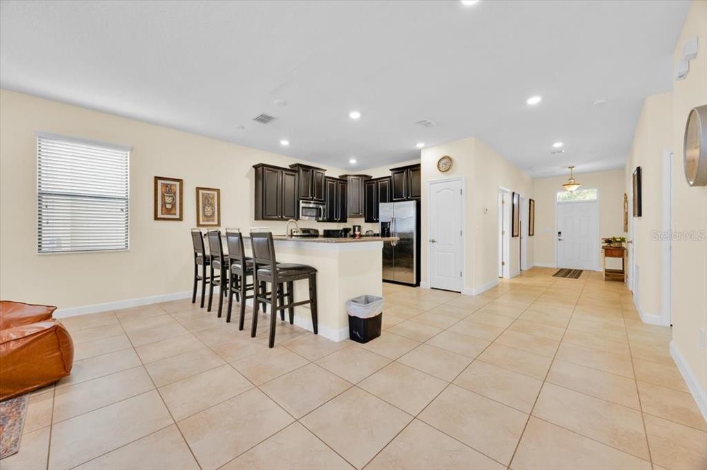 9032 Shadow Mountain Street Davenport, FL 33896 - Photo 10 of 43 a kitchen with stainless steel appliances kitchen island granite countertop a refrigerator and a sink
