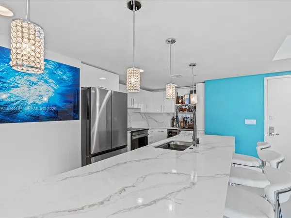 a kitchen with kitchen island a stove a sink and a refrigerator