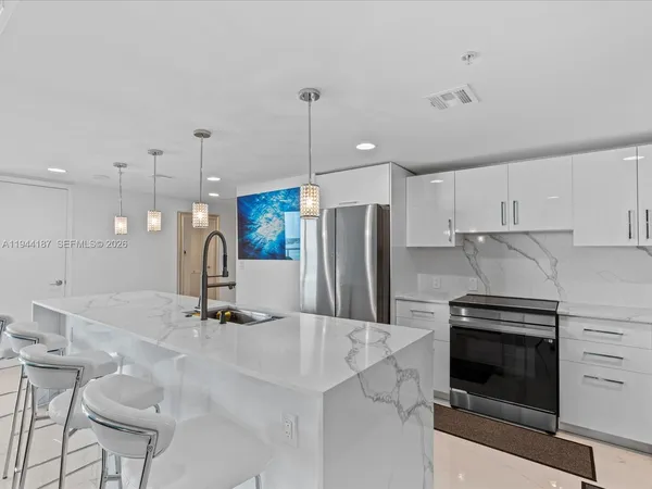 a kitchen with stainless steel appliances white cabinets and a refrigerator
