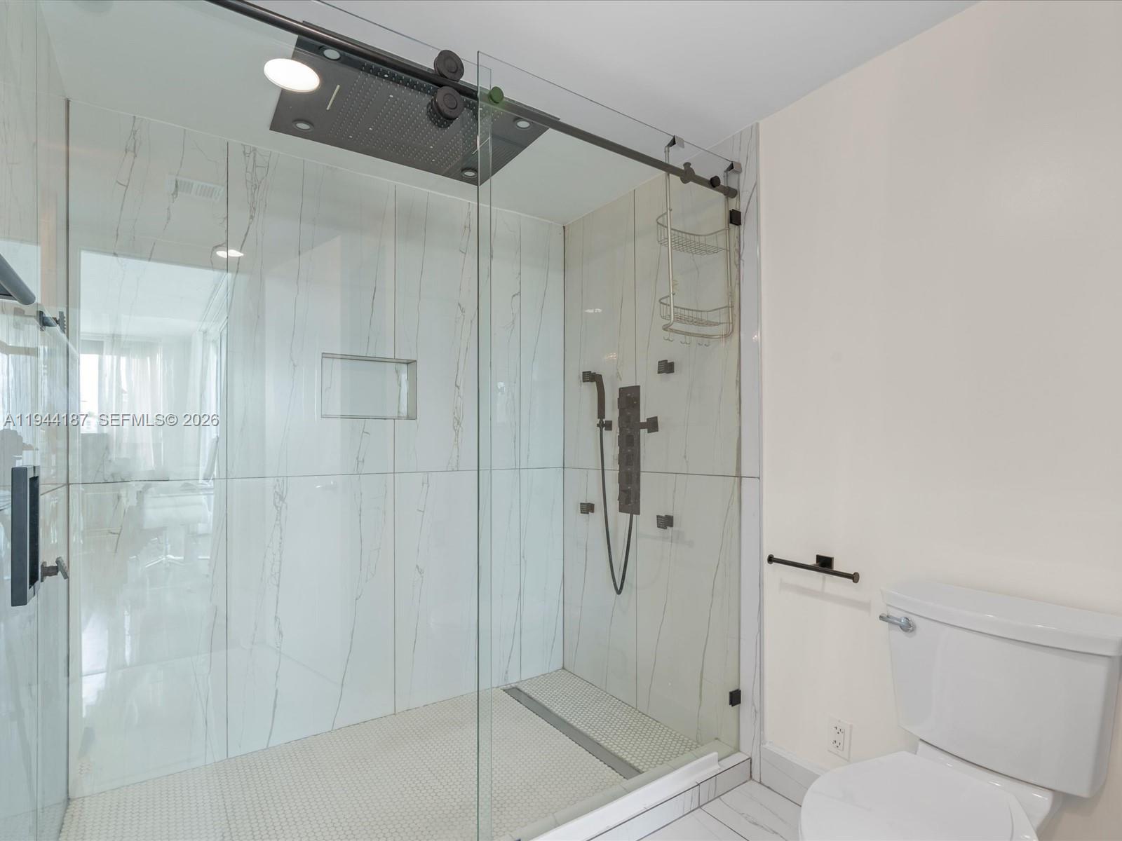 665 Northeast 25th Street, Unit 1101 Miami, FL 33137 - Photo 31 of 47 a bathroom with a shower and toilet