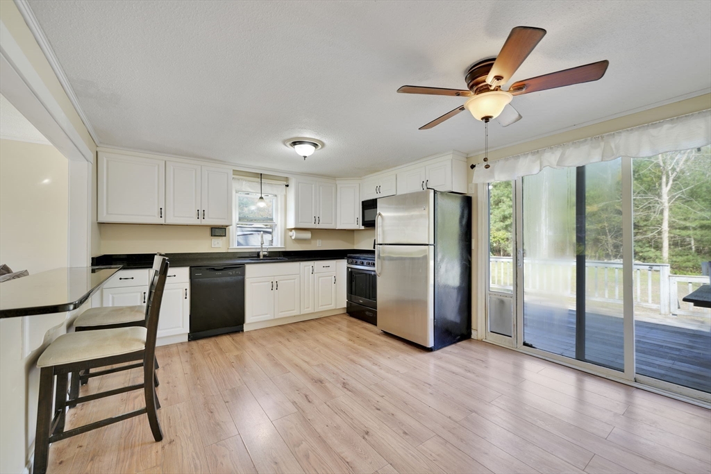 41 Standish Avenue Wareham, MA 02538 - Photo 9 of 35 a kitchen with stainless steel appliances a refrigerator a sink dishwasher a stove and white cabinets with wooden floor