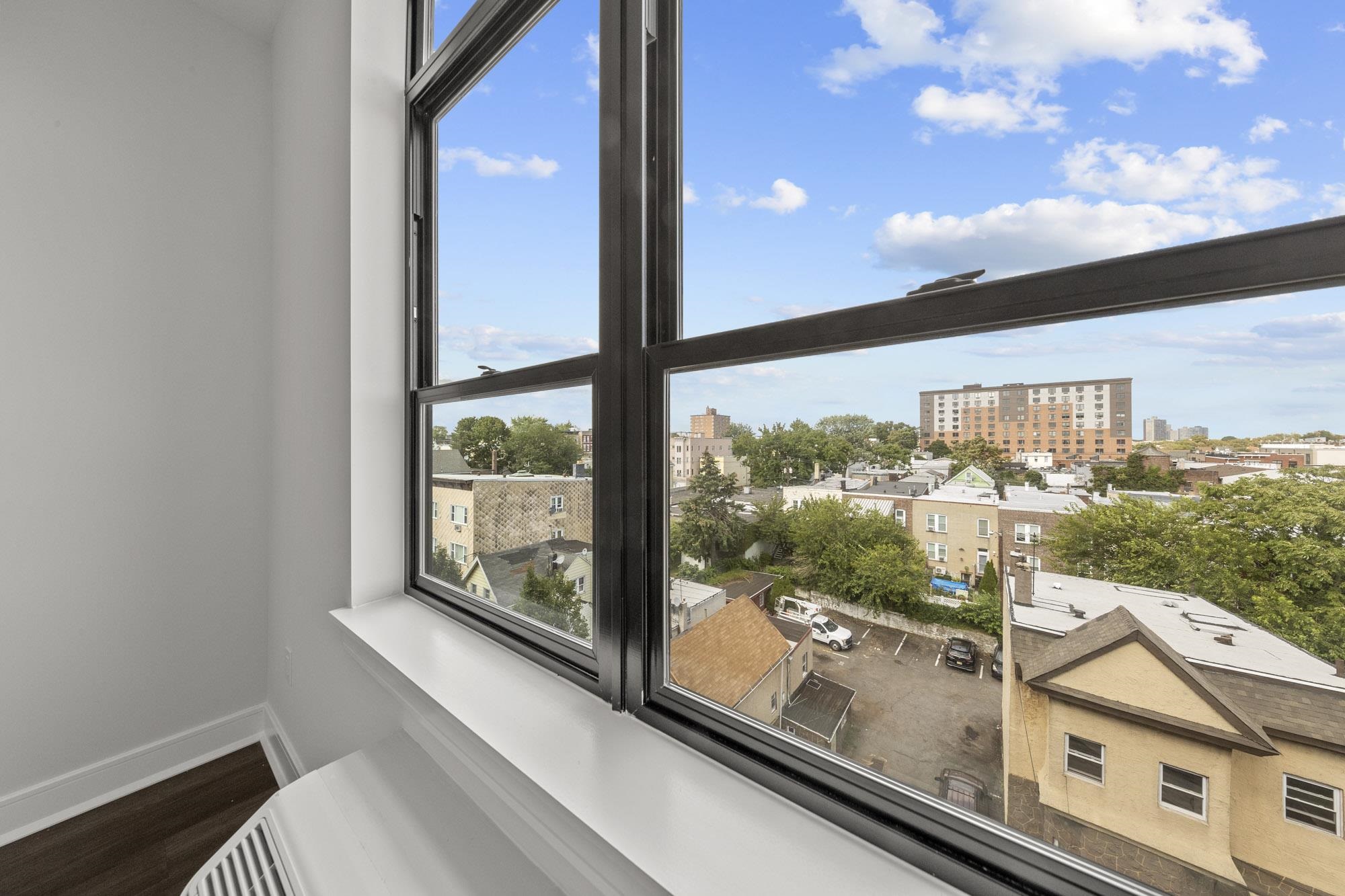 121 34th Street, Unit 401 Union City, NJ 07087 - Photo 15 of 44 a view of a balcony with a floor to ceiling window and wooden floor