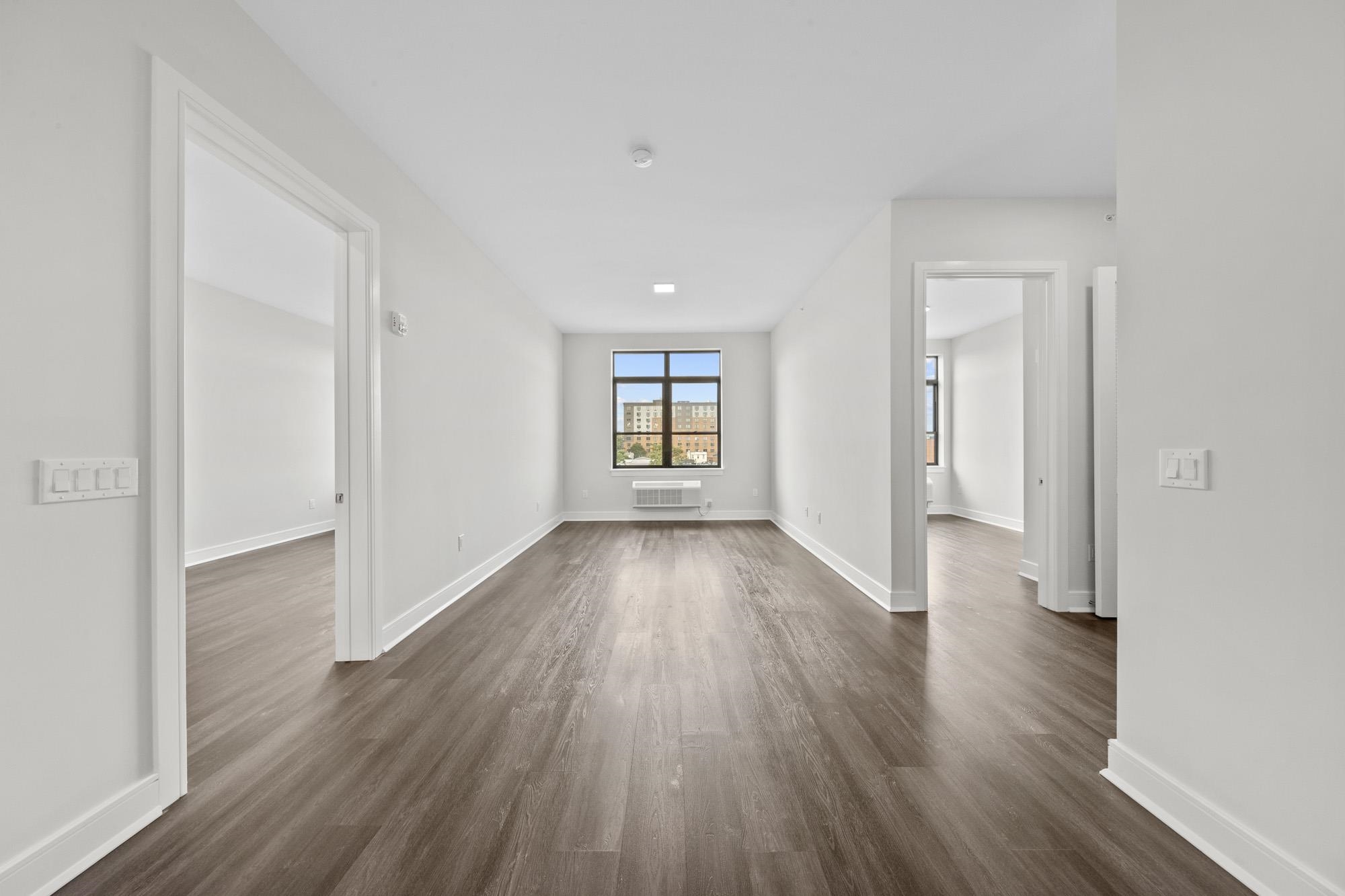 121 34th Street, Unit 401 Union City, NJ 07087 - Photo 6 of 44 an empty room with wooden floor and windows