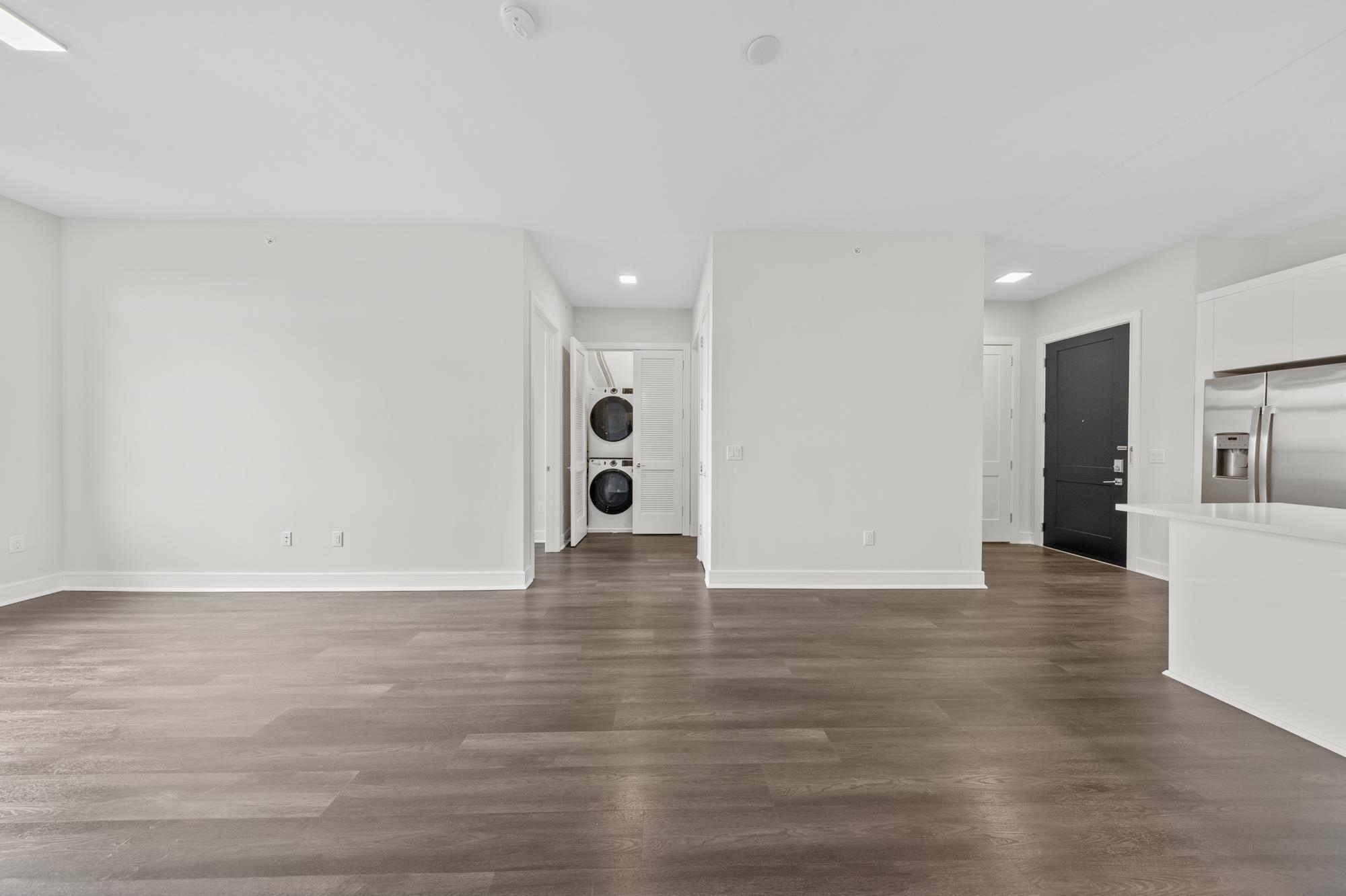 121 34th Street, Unit 401 Union City, NJ 07087 - Photo 7 of 44 a view of an empty room with wooden floor and a window