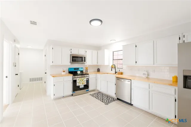 a kitchen with a sink window and white cabinets