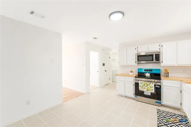 a large white kitchen with stainless steel appliances