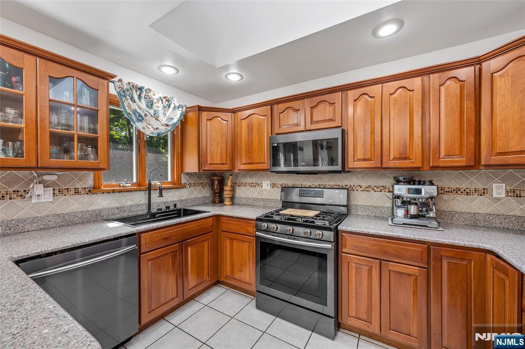 21 Marcia Road Ringwood, NJ 07456 - Photo 12 of 42 a kitchen with stainless steel appliances granite countertop a sink stove microwave and cabinets