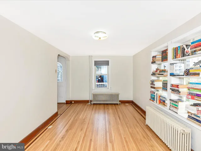 a living room with a bed furniture and next to a window