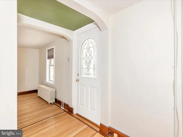a view of a room with wooden floor a ceiling fan and window