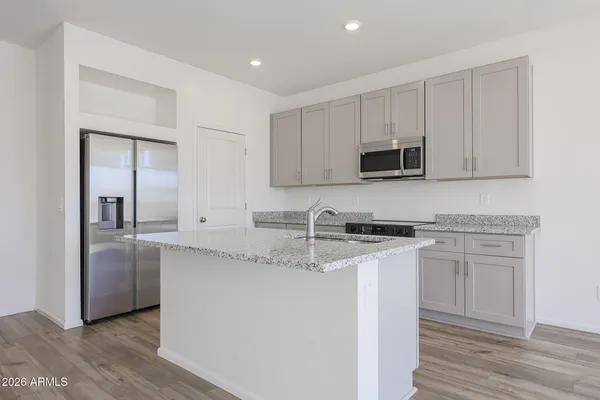 a kitchen with stainless steel appliances granite countertop a stove a sink and a microwave