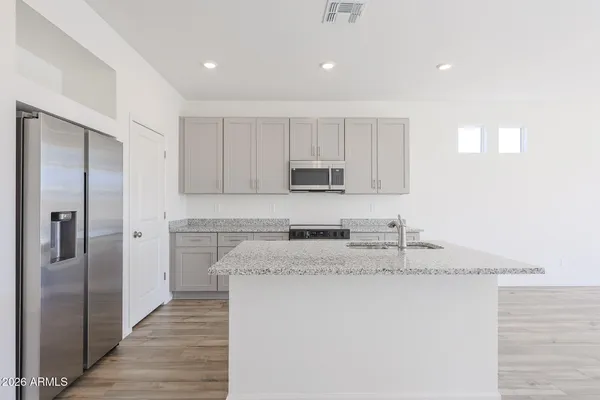 a kitchen with stainless steel appliances granite countertop a refrigerator a stove and a sink