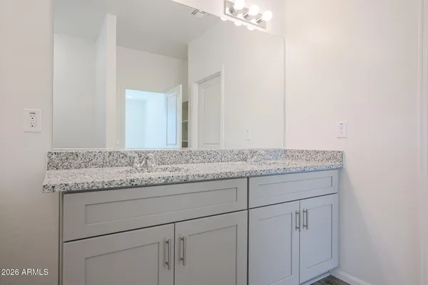 a bathroom with a granite countertop sink and white cabinets