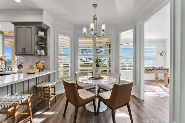 a dining room with furniture a chandelier and wooden floor
