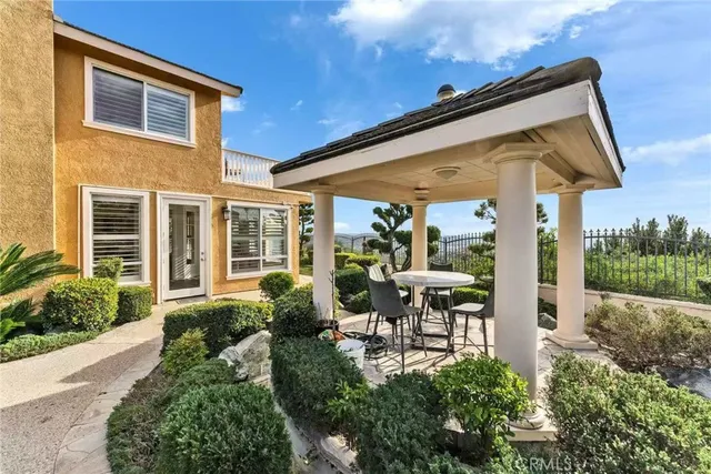 a view of a chair and tables in the patio in front of a house