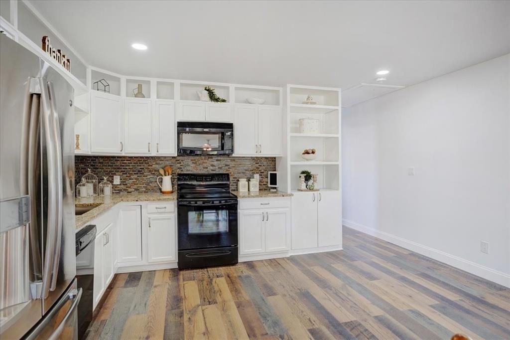 402 West Sam Rayburn Drive Ector, TX 75439 - Photo 16 of 40 a kitchen with white cabinets and stainless steel appliances