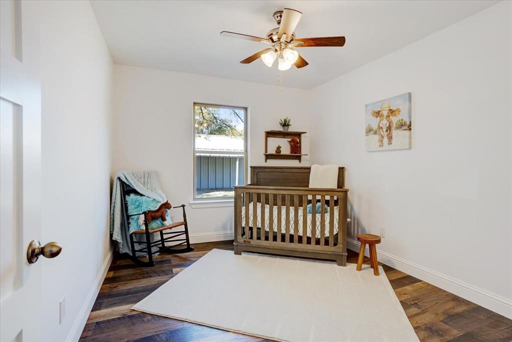 402 West Sam Rayburn Drive Ector, TX 75439 - Photo 22 of 40 a bedroom with a bed and a chandelier