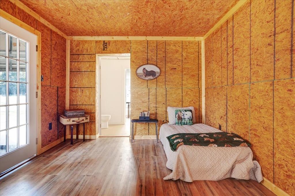 402 West Sam Rayburn Drive Ector, TX 75439 - Photo 23 of 40 a bedroom with a bed and wooden floor