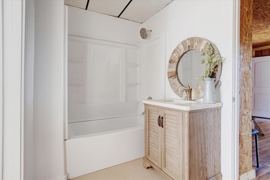 402 West Sam Rayburn Drive Ector, TX 75439 - Photo 26 of 40 a bathroom with a mirror sink and a mirror