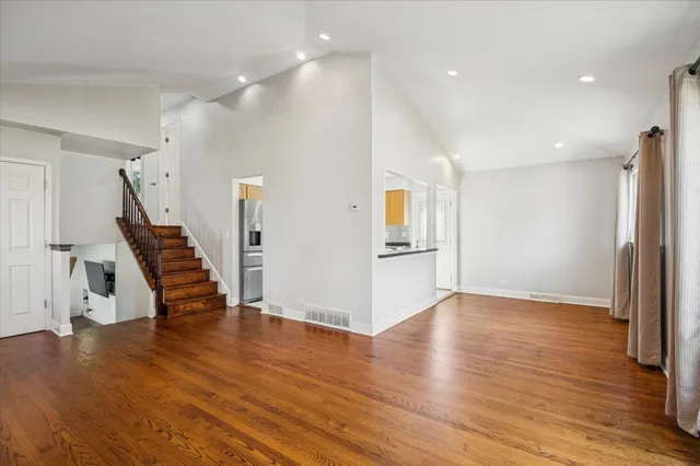a view of an entryway with wooden floor and a kitchen view