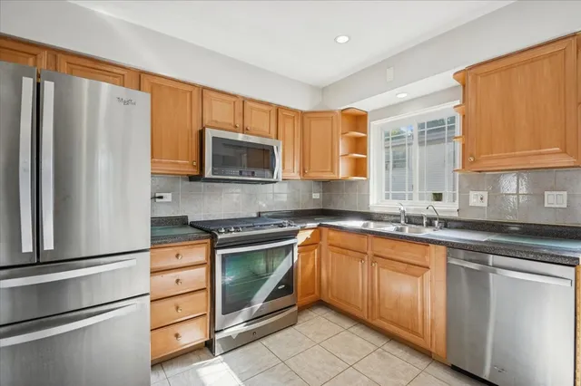 a kitchen with granite countertop a sink stainless steel appliances and cabinets