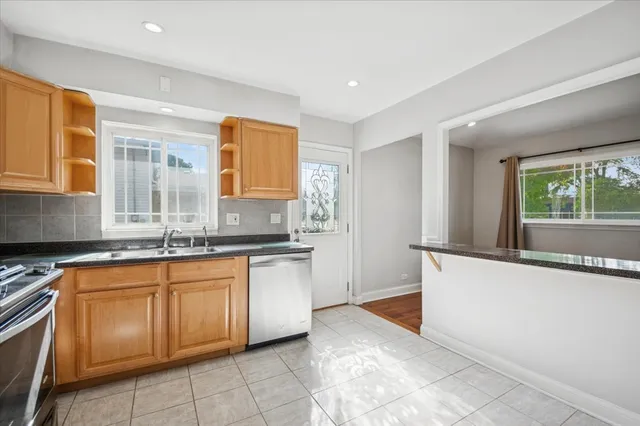 a large kitchen with granite countertop a sink and a stove